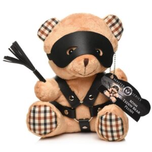 wears a faux leather harness with metal O-rings