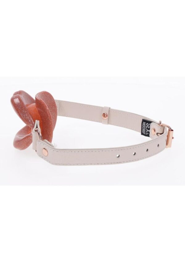 the Peaches n CreaMe Lips Gag adds a playful twist to your intimate moments. Explore a new flavor of kinky play and leave your bottom silently begging for more.Features:Open mouth silicone lip gag with pearlescent hueFaux leather strap and buckle adjustmentNickel-free rose gold accents